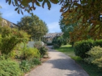 großzügige Einfahrt - Luxus im Grünen: Repräsentative Weinstraßen Villa mit parkartigem Garten in Ortsrandlage